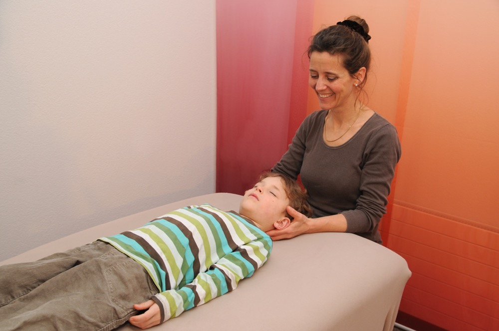 Junge liegend w&auml;hrend Behandlung am Kopf