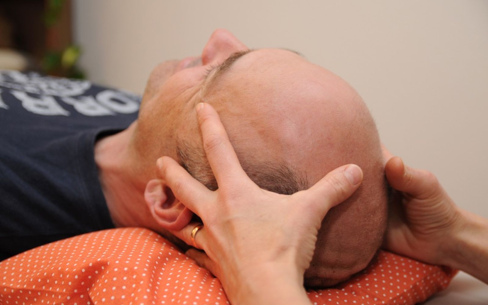Therapeutin behandelt Kopf eines Patienten