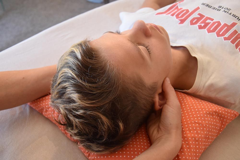 Junge liegend bei Craniosacraltherapie an den Augen